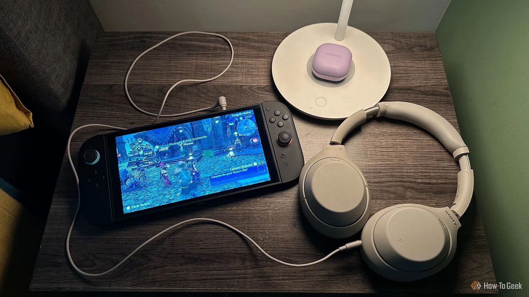 Bàn đầu giường với Nintendo Switch 2 và tai nghe Sony WH-1000XM4.