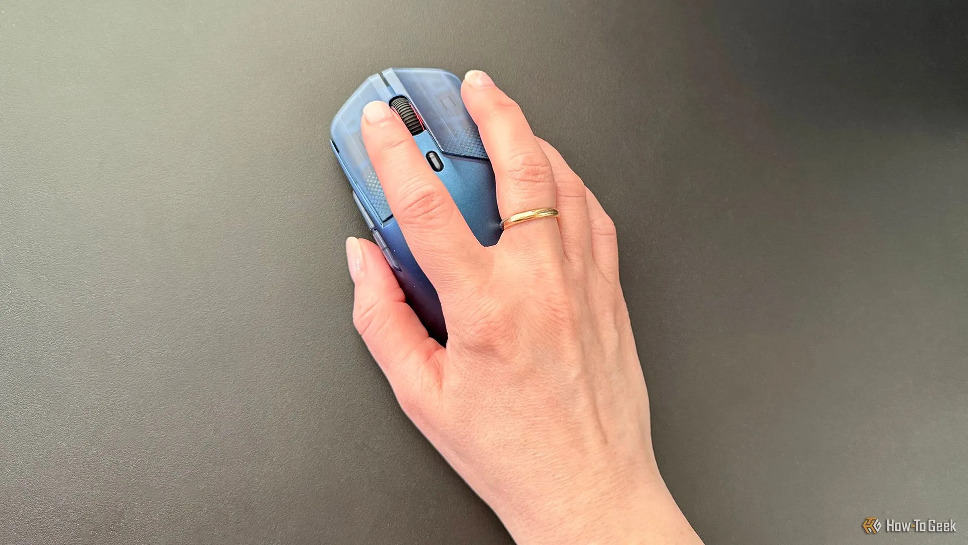 Bàn tay đang đặt trên chuột gaming HyperX Pulsefire Haste 2 S khi chơi game, thể hiện sự thoải mái và độ bám.