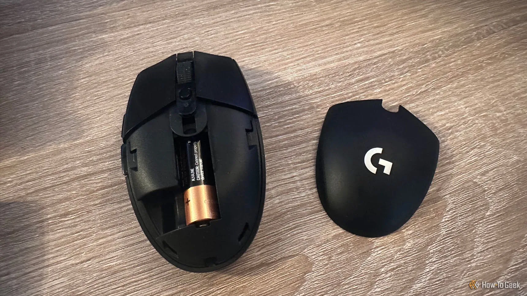 Bên trong chuột Logitech G305 khi tháo nắp, lộ ra khay pin AA.