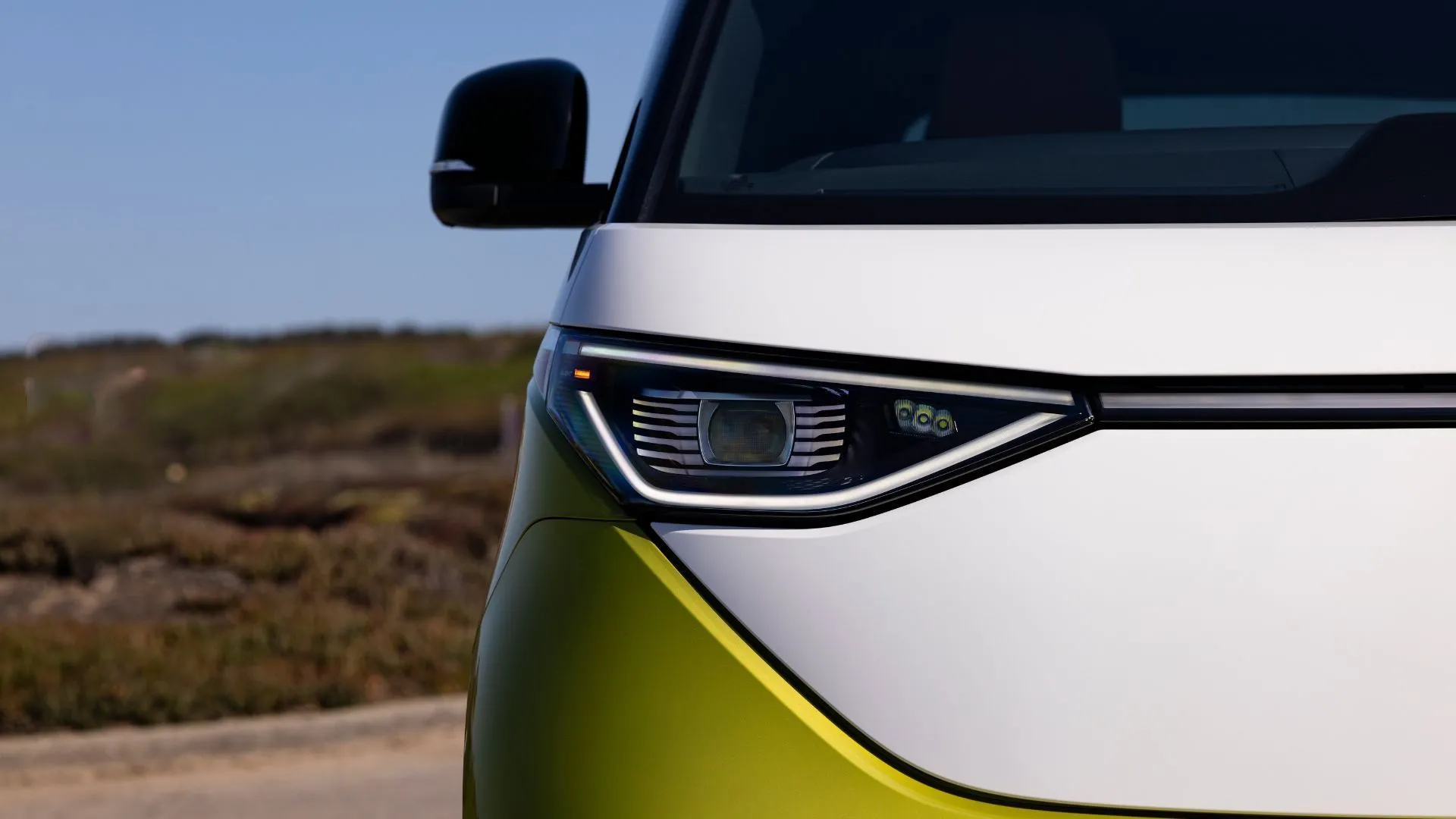 Đèn pha và mặt trước của xe điện Volkswagen ID. Buzz 2025 màu vàng.