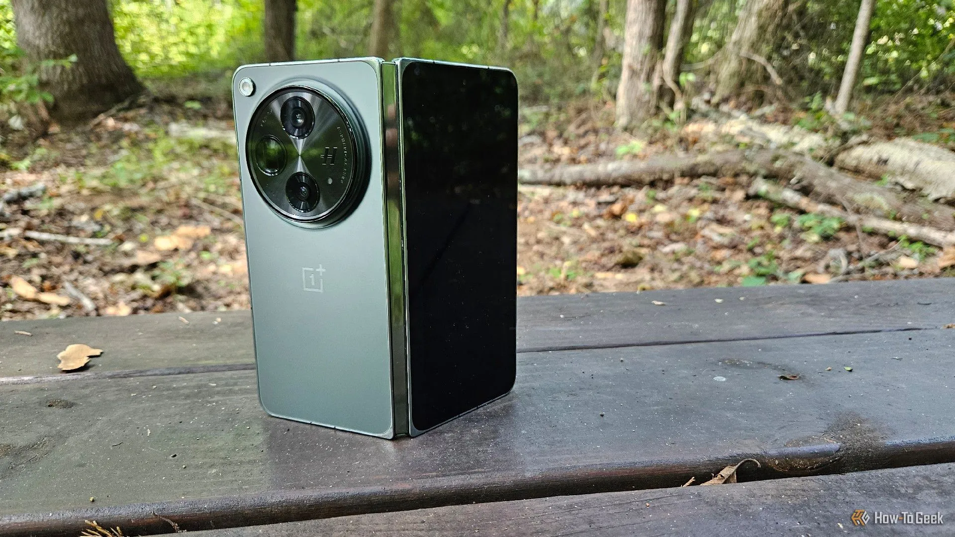 Điện thoại OnePlus Open đặt đứng trên ghế đá, thể hiện thiết kế mở