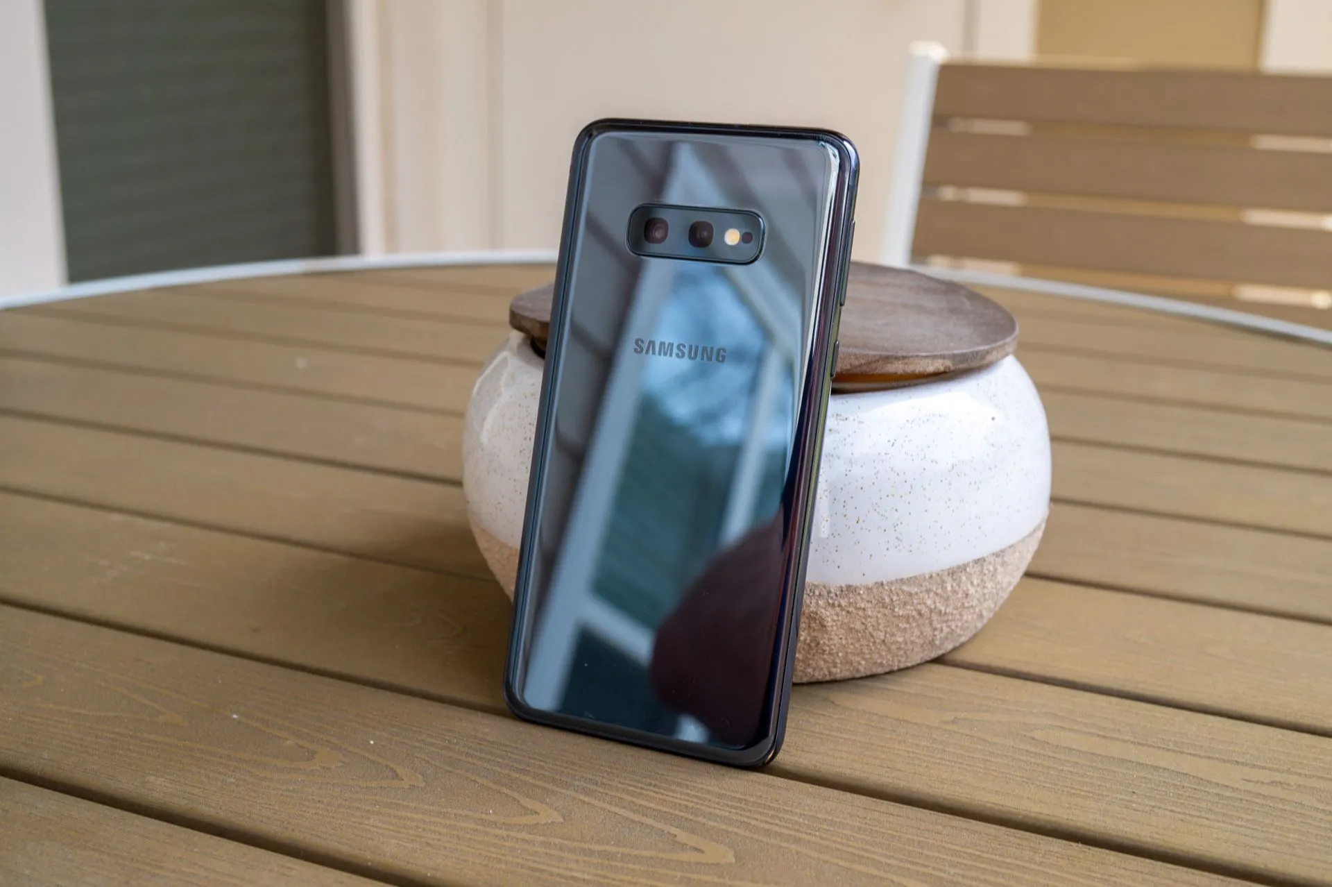 Điện thoại Samsung Galaxy S10e màu trắng đặt trên mặt bàn, thể hiện kích thước nhỏ gọn và thiết kế cao cấp