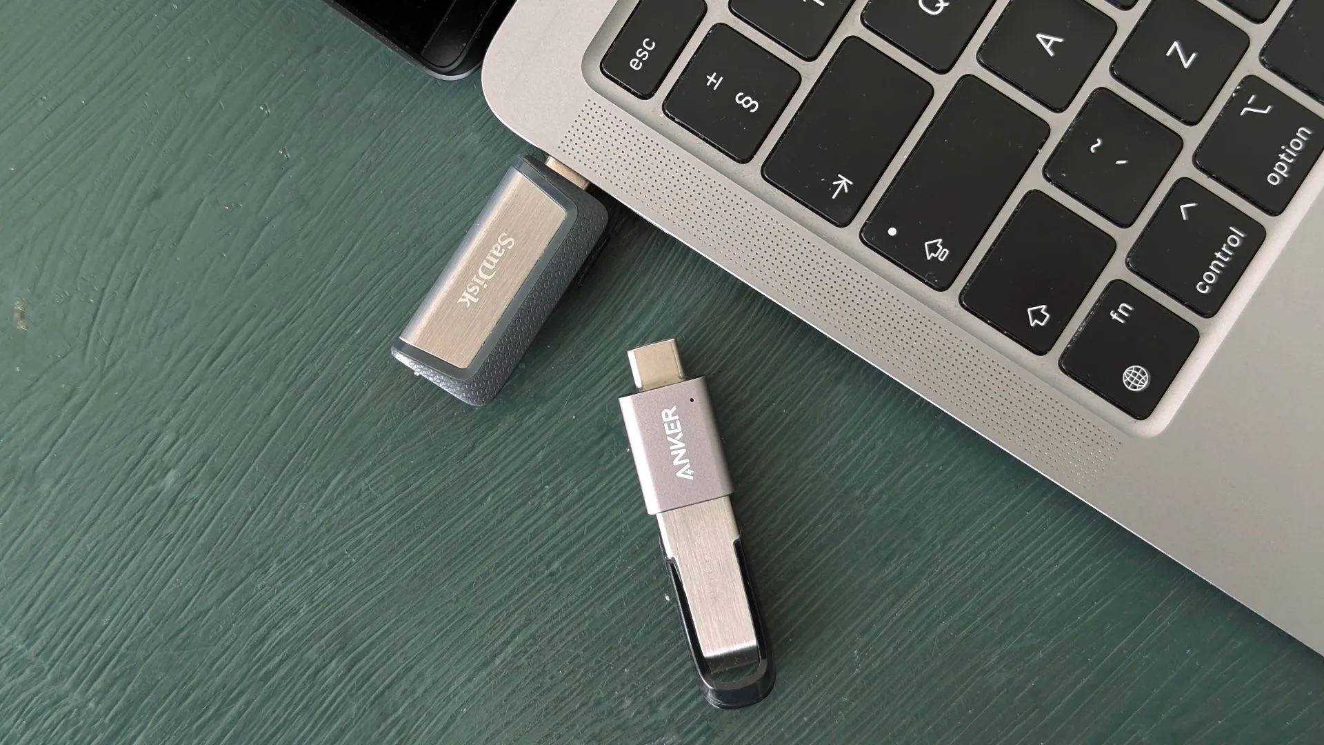 Hình ảnh các USB flash drive thế hệ mới bên cạnh MacBook, minh họa tính di động và đa năng.