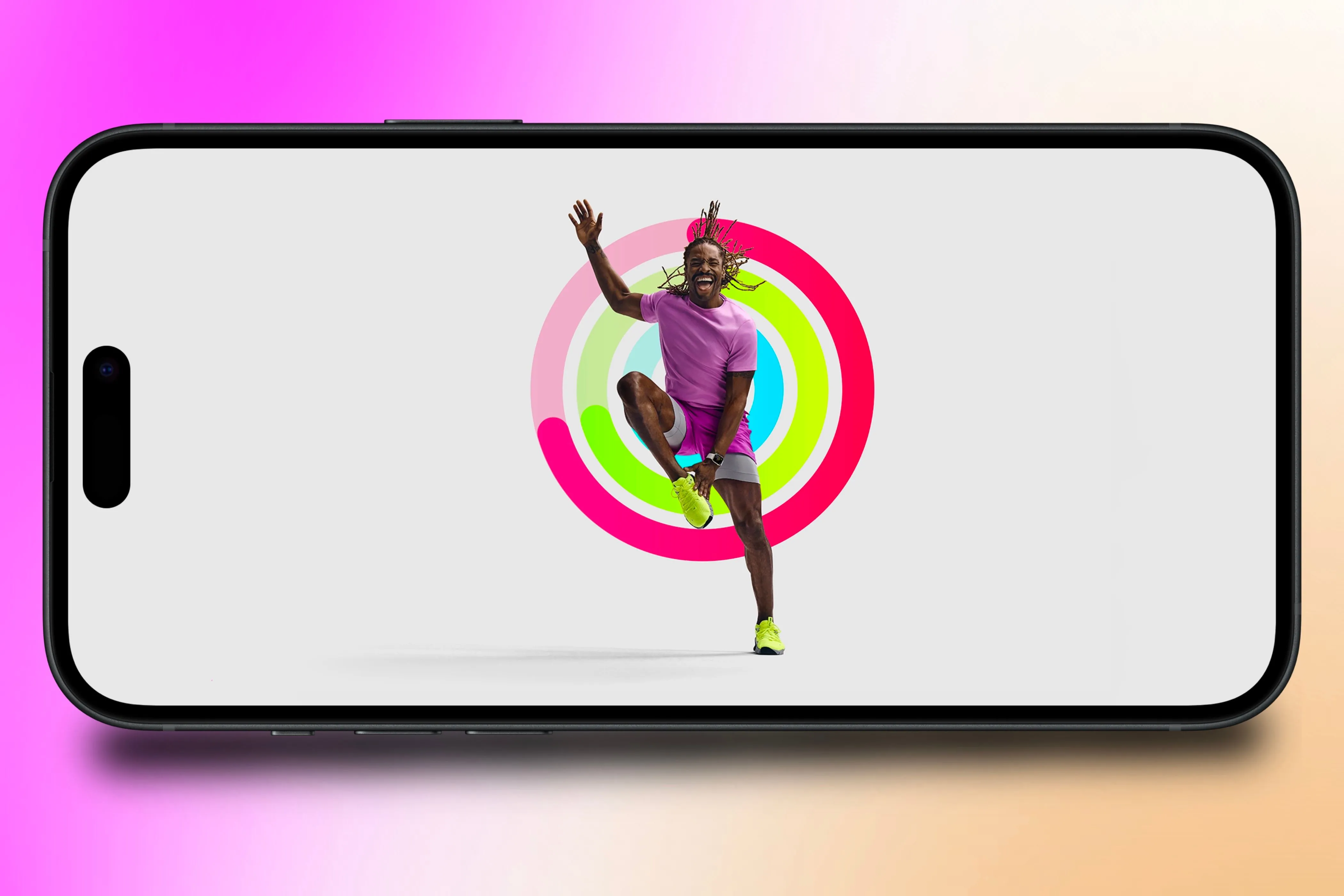 Huấn luyện viên Apple Fitness+ với Vòng Hoạt Động hiển thị trên iPhone, biểu tượng cho sức khỏe và mục tiêu năm mới