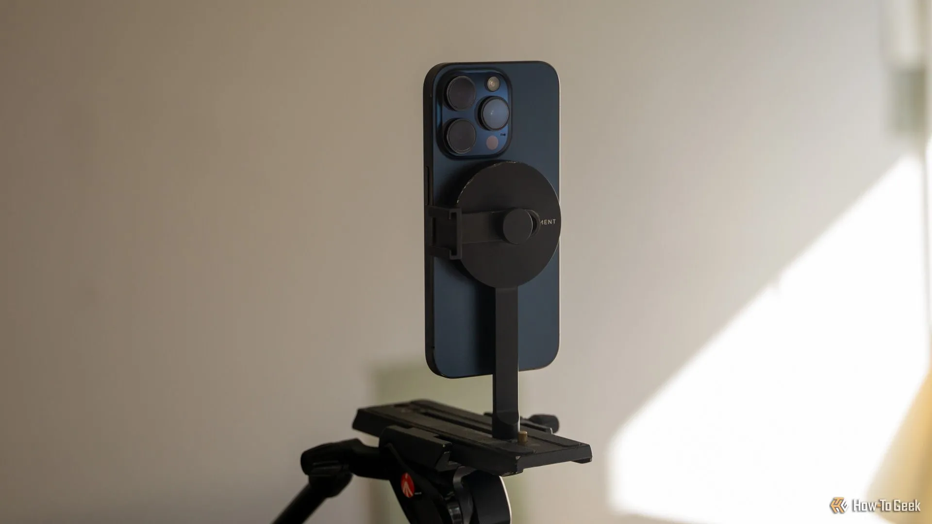 iPhone 15 Pro gắn dọc trên chân máy tripod MagSafe Moment, thể hiện khả năng xoay linh hoạt
