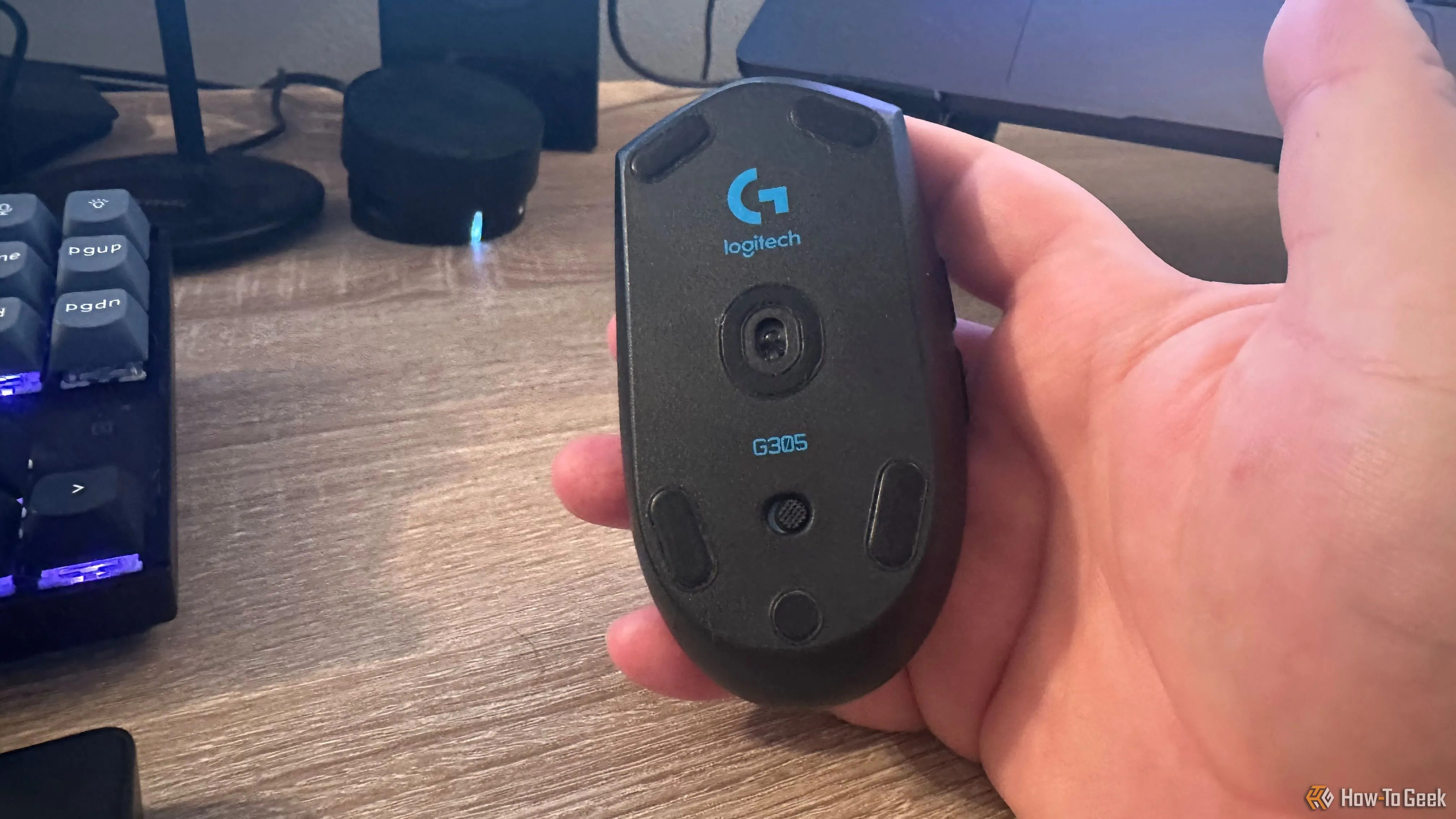 Mặt dưới của chuột gaming Logitech G305 Lightspeed, hiển thị cảm biến Hero và nắp pin.
