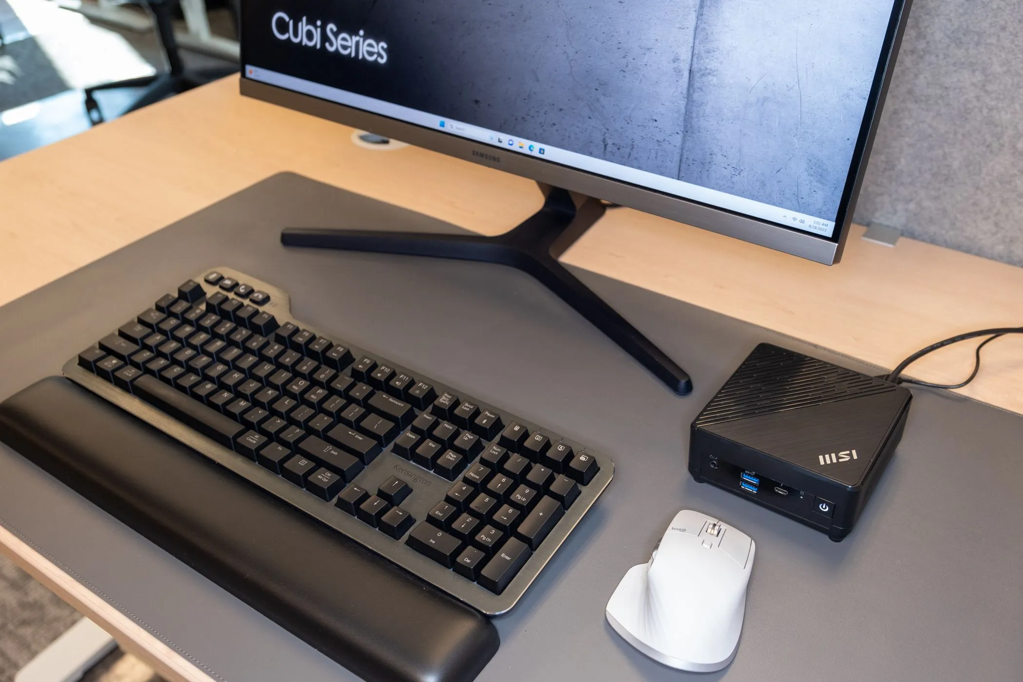 Máy tính mini MSI Cubi 5 12M đặt trên bàn làm việc cùng chuột, bàn phím và màn hình