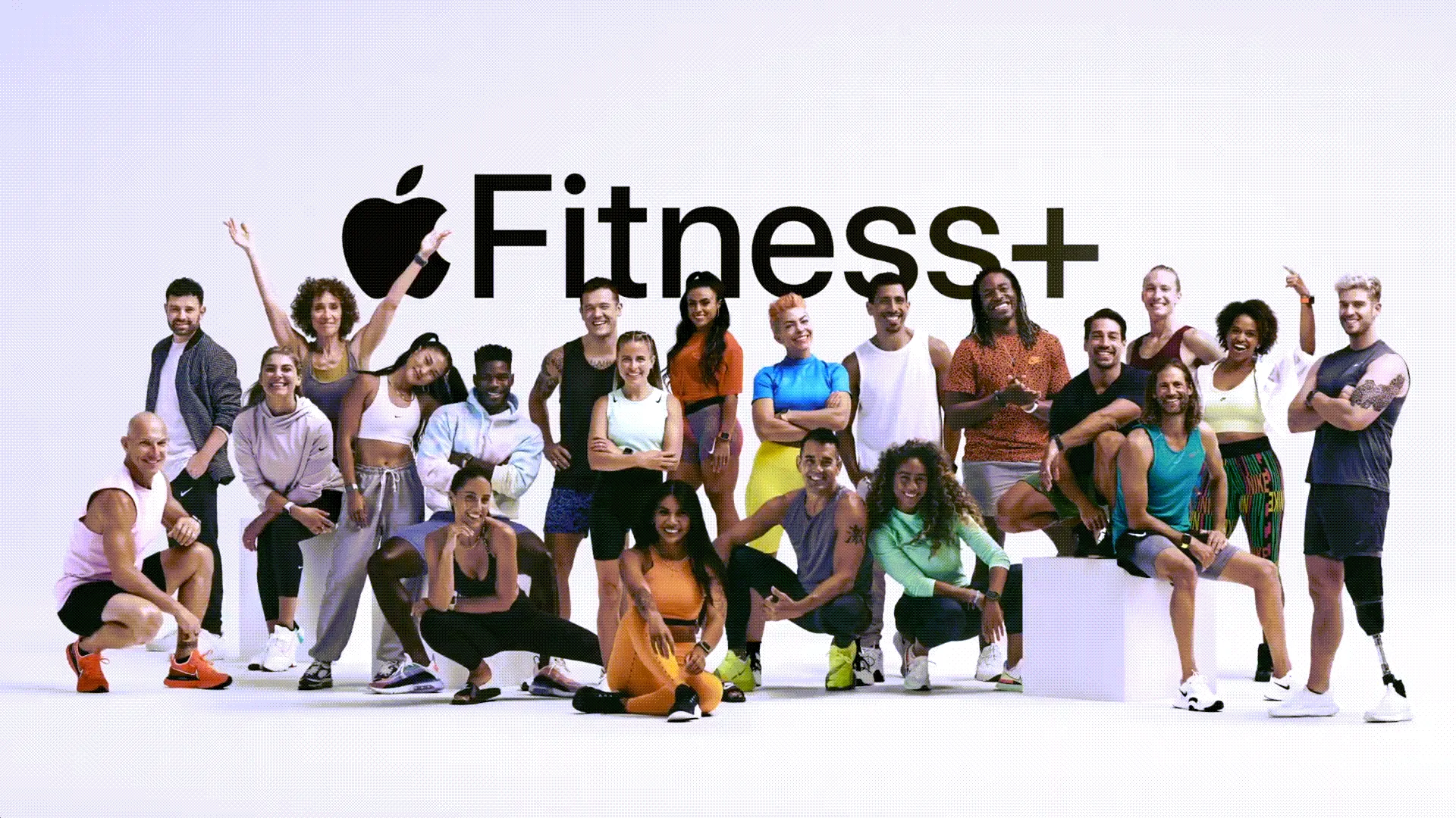 Một nhóm đông đảo huấn luyện viên thể hình trước logo Apple Fitness+