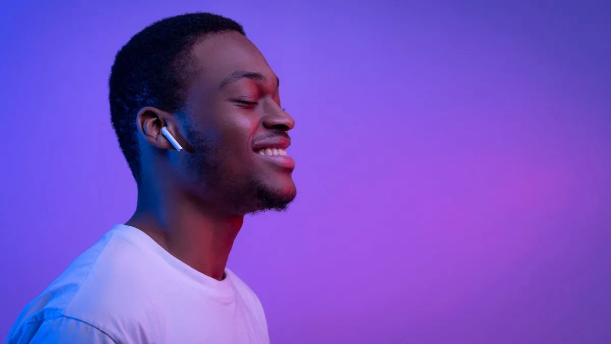Người đàn ông thư giãn đeo tai nghe Apple AirPods, minh họa cho việc nghe thiền hoặc nhạc thư giãn.