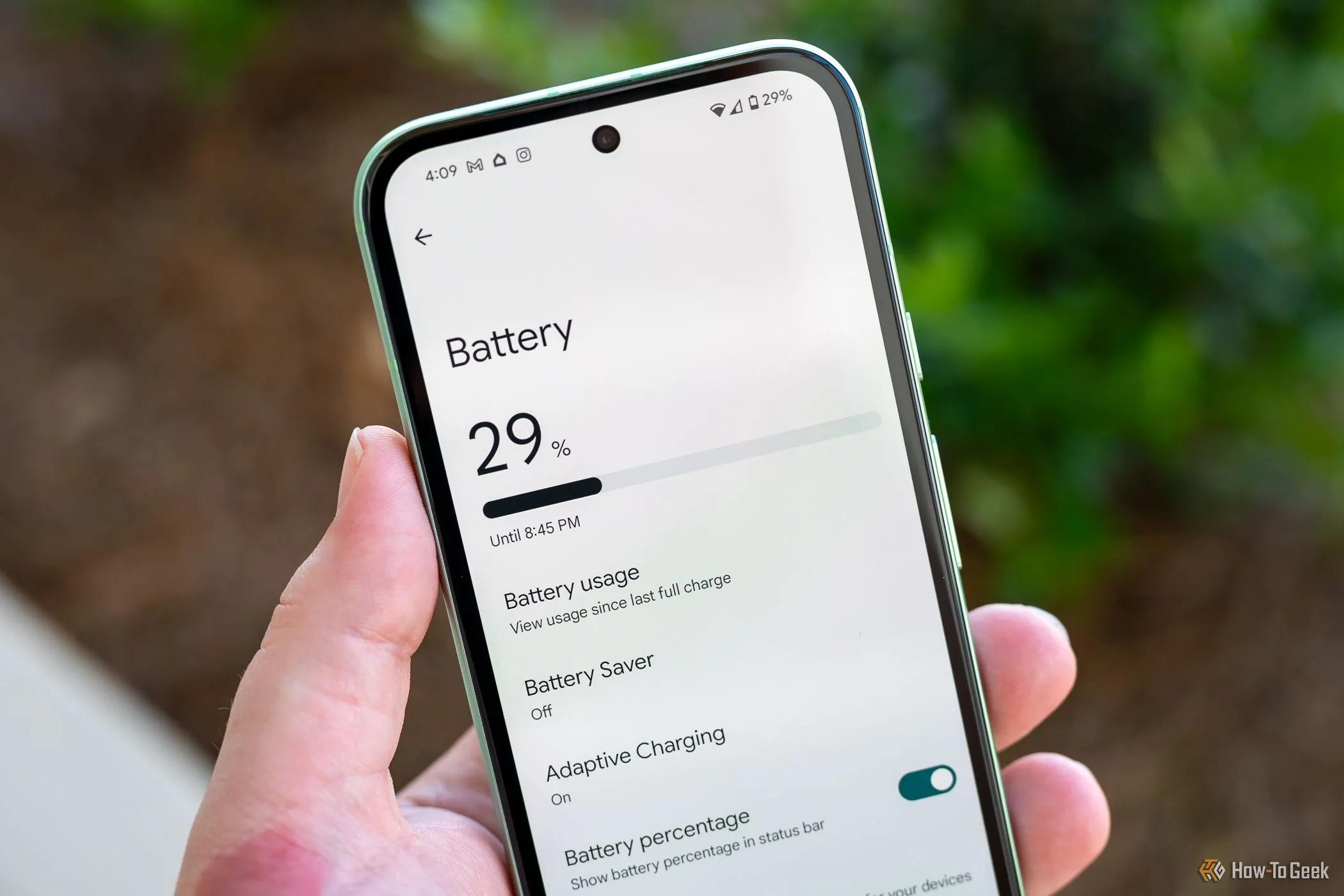 Người dùng cầm Google Pixel 8a và xem menu cài đặt pin