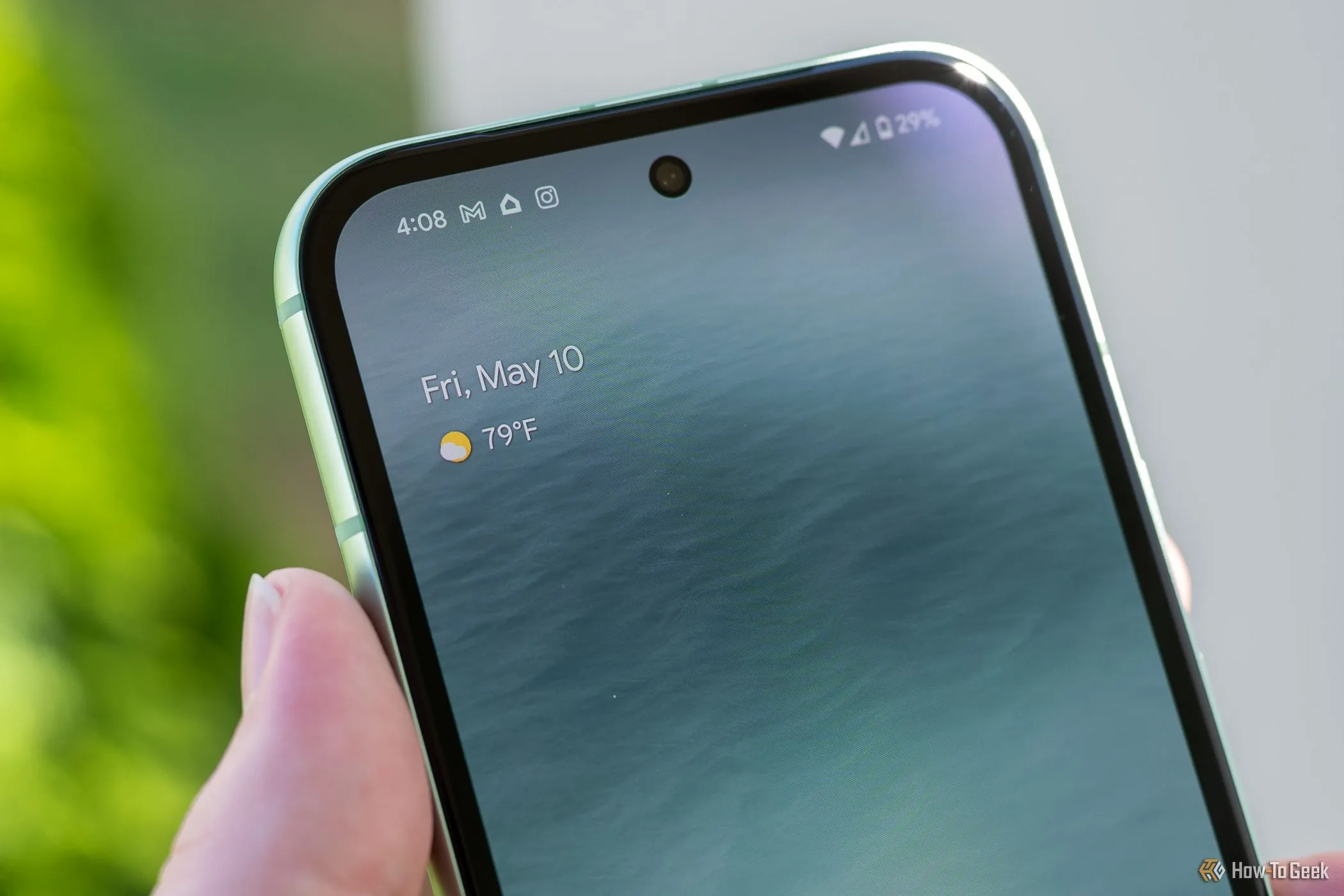 Người dùng cầm Google Pixel 8a với camera trước đang bật