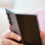 Người dùng cầm Samsung Galaxy Z Fold 6 mở hé, nhìn vào cụm camera sau