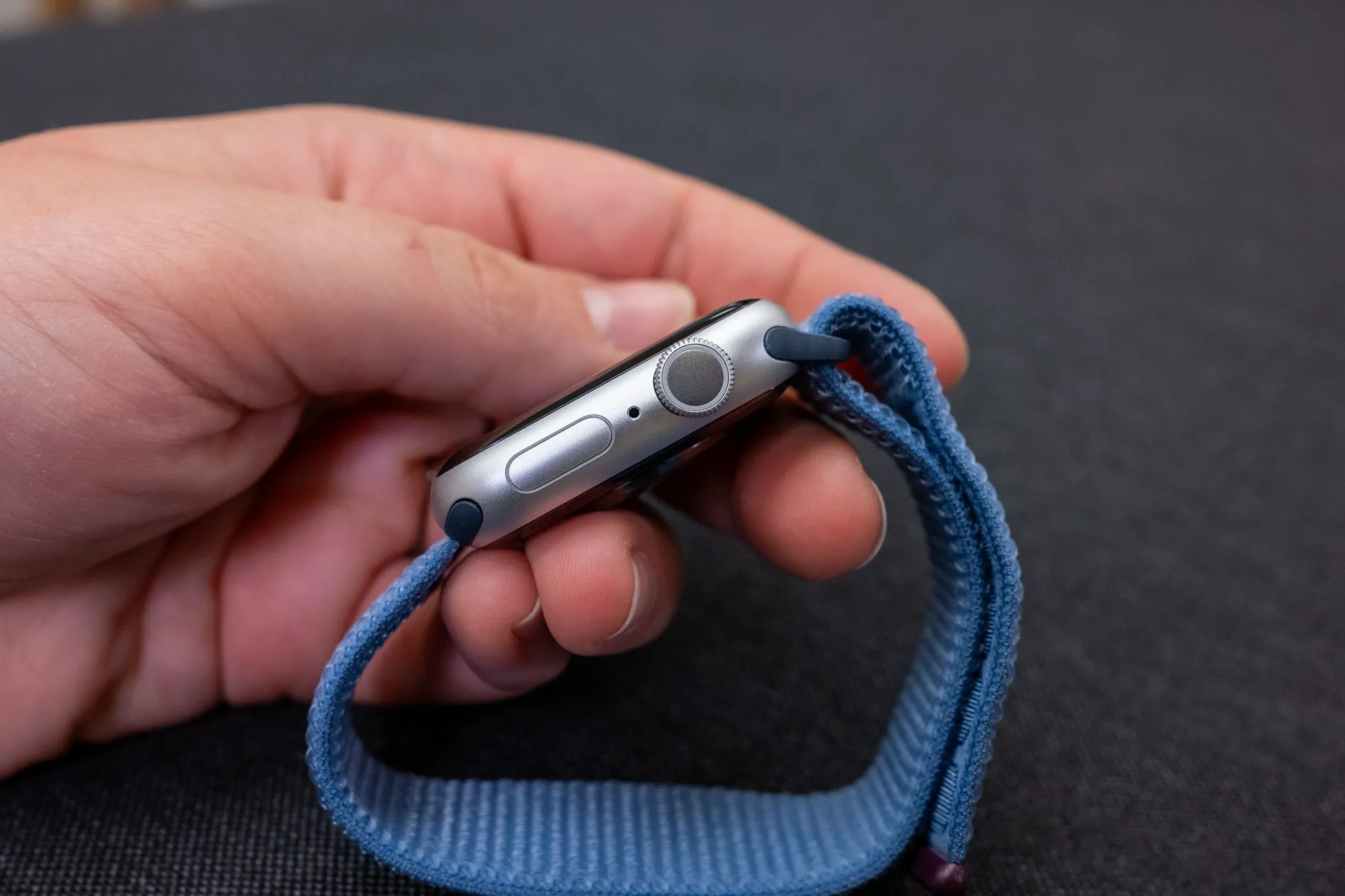 Người dùng cầm trên tay Apple Watch Series 9, thể hiện thiết kế tổng thể của thiết bị.