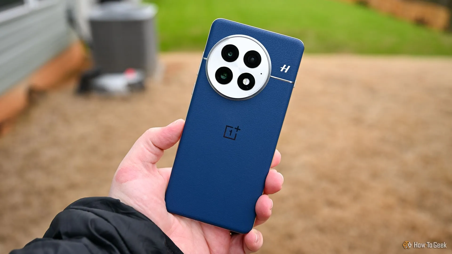 Người dùng đang cầm điện thoại OnePlus 13 màu xanh, minh họa một trong những smartphone tiên phong áp dụng công nghệ pin silicon-carbon.