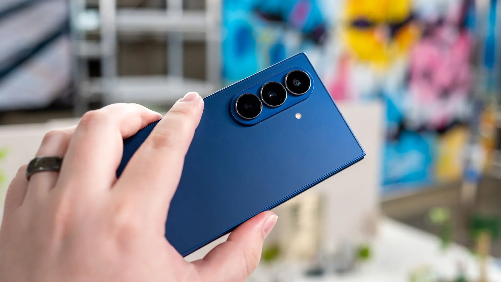 Người dùng đang cầm Galaxy Z Fold 7 mở ra, hiển thị mặt lưng và cụm camera sau