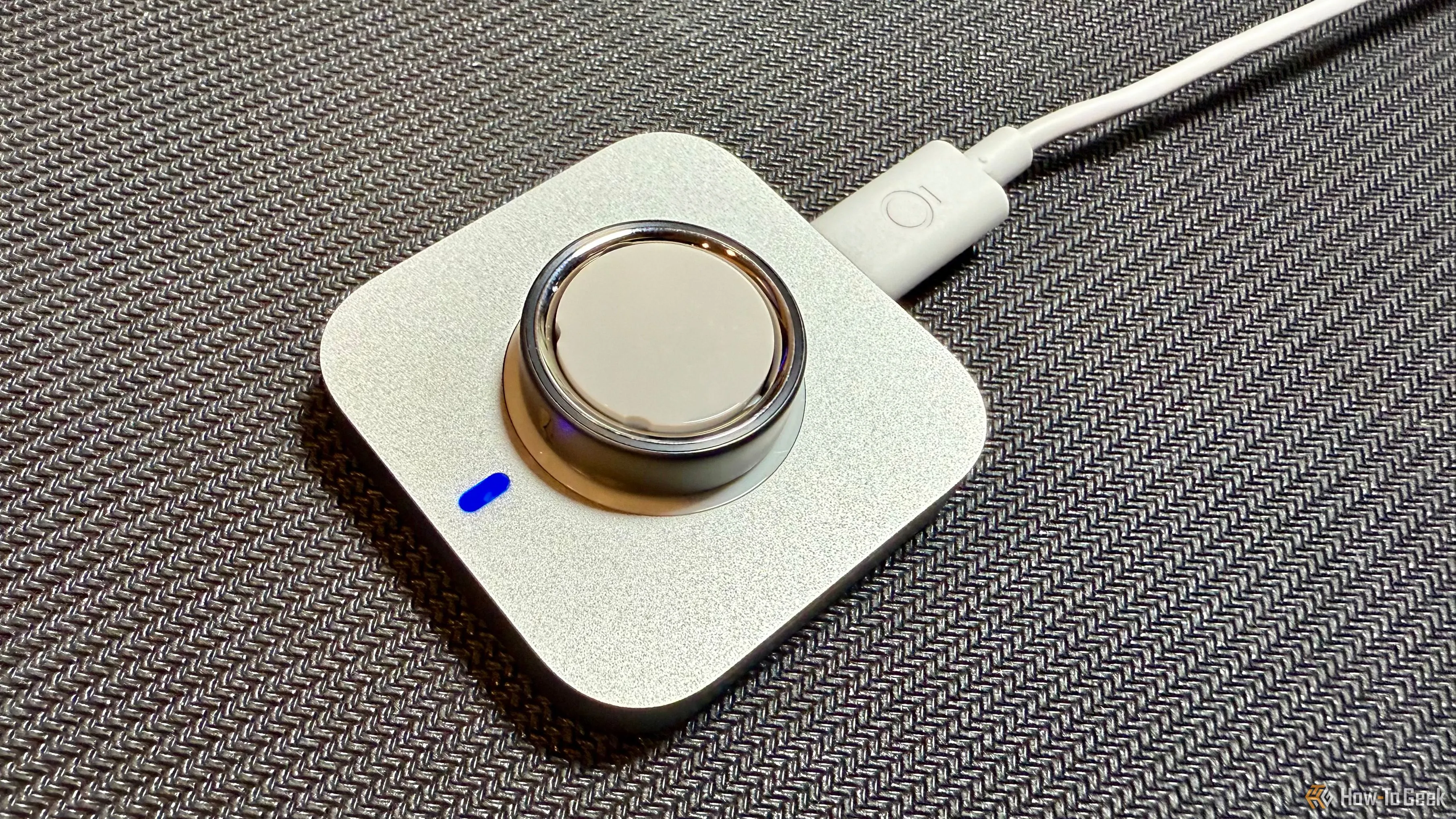 Oura Ring 4 đang được đặt trên đế sạc