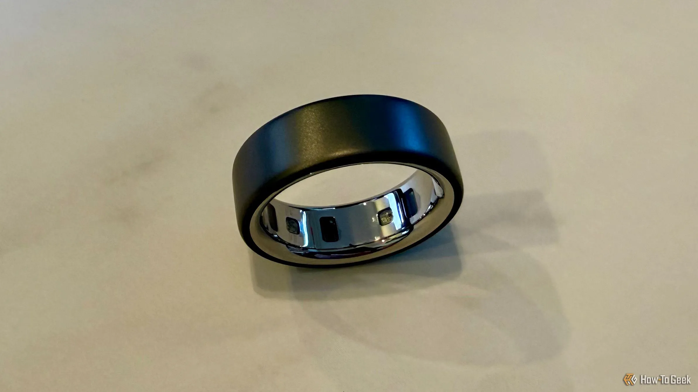 Oura Ring 4 đặt trên bàn, hiển thị các cảm biến bên trong