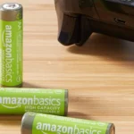 Pin sạc AA AmazonBasics và bộ điều khiển Xbox trên bàn gỗ