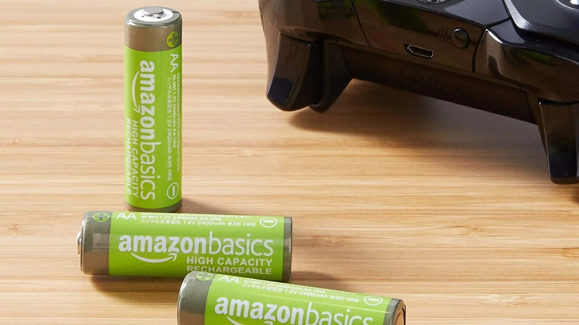 Pin sạc AA AmazonBasics và bộ điều khiển Xbox trên bàn gỗ