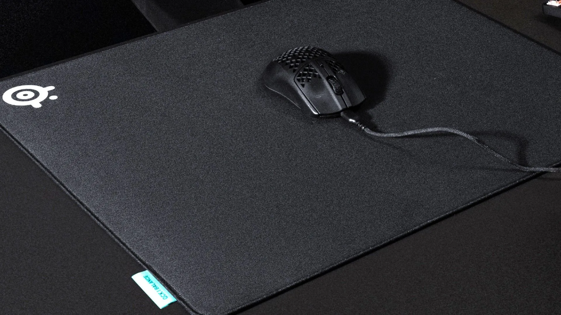 Thảm chuột SteelSeries QcK Performance màu đen với logo và một con chuột chơi game đặt trên đó