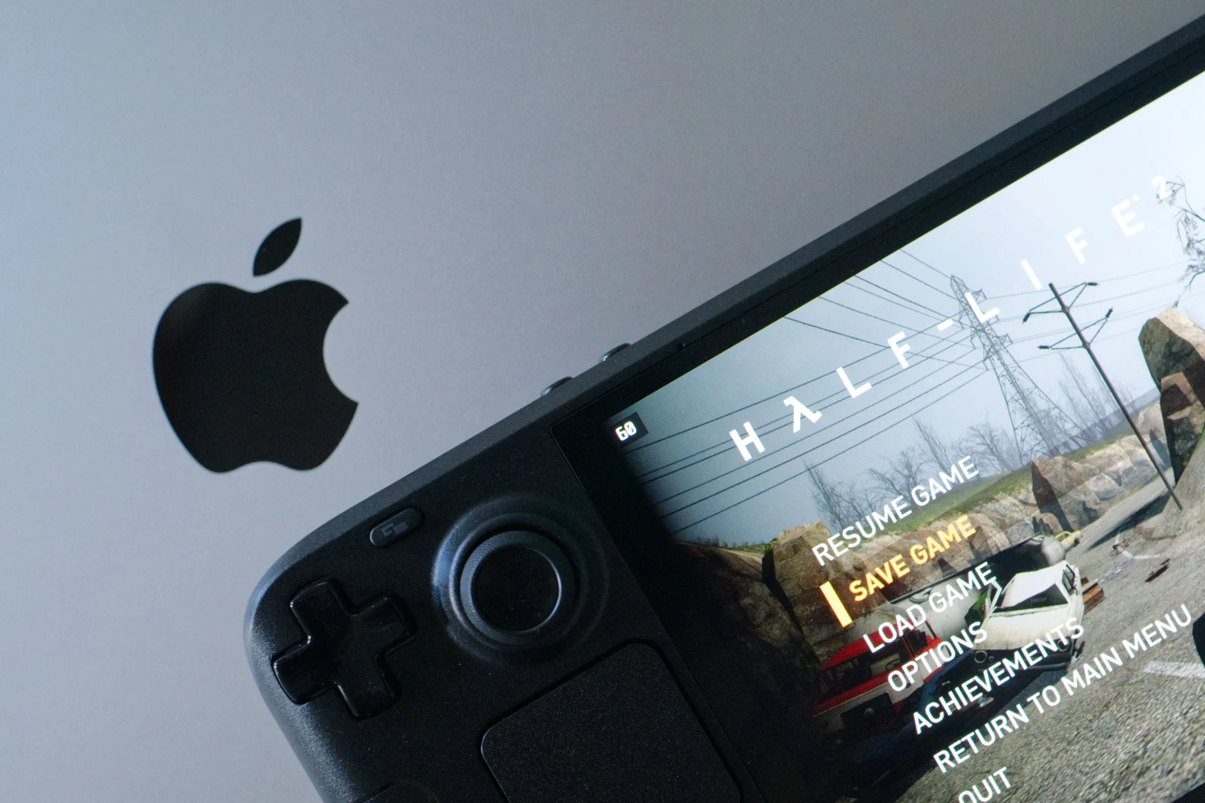 Trải nghiệm chơi Half-Life 2 mượt mà trên Steam Deck OLED đặt cạnh MacBook Pro, thể hiện sự linh hoạt của thiết bị chơi game cầm tay.